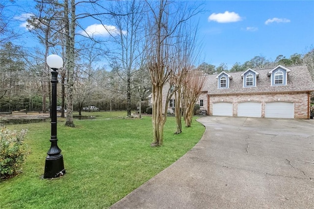 exterior space with brick siding, driveway, a front lawn, and roof with shingles