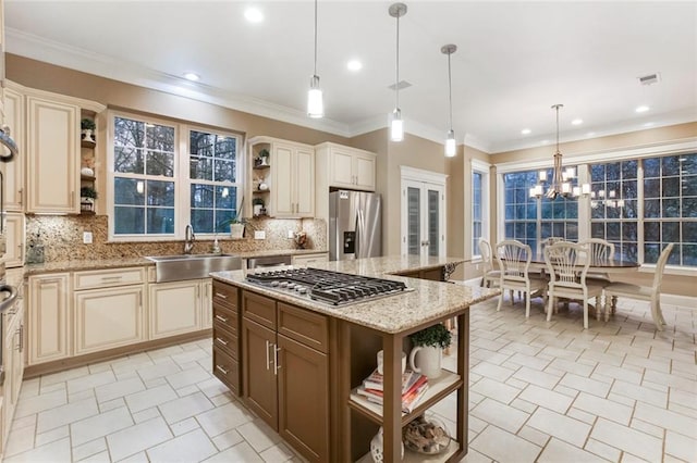 kitchen with a sink, open shelves, cream cabinets, and stainless steel appliances