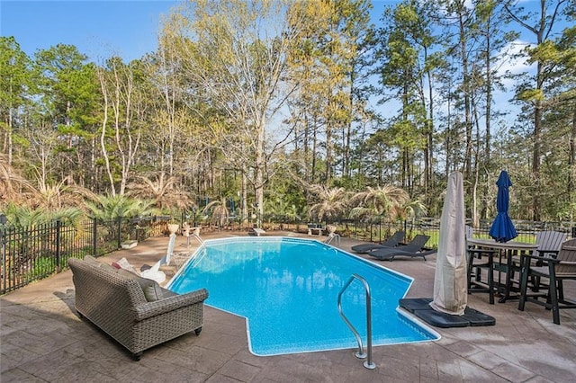 view of swimming pool featuring a patio area, a fenced in pool, and fence