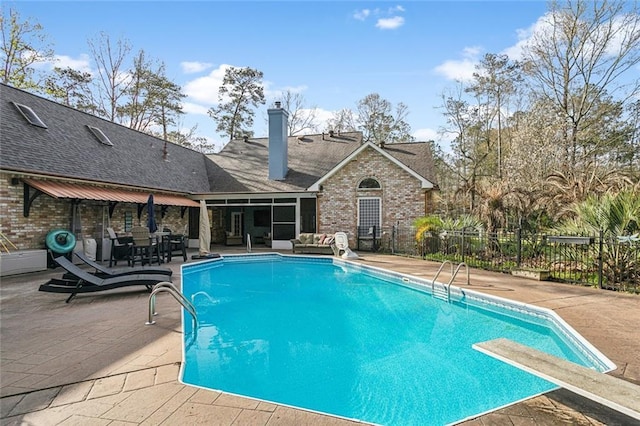 view of swimming pool with a diving board, a fenced in pool, a patio, and fence