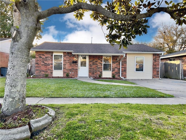 ranch-style house featuring brick siding, a front lawn, and fence