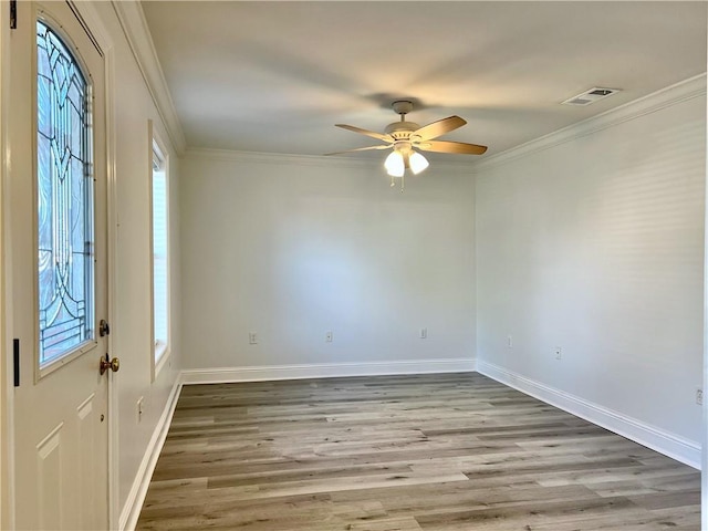 foyer entrance featuring visible vents, wood finished floors, and ornamental molding