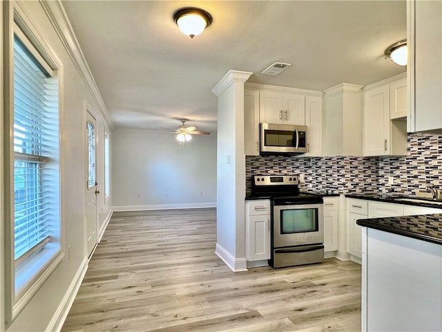 kitchen with a ceiling fan, visible vents, appliances with stainless steel finishes, dark countertops, and tasteful backsplash