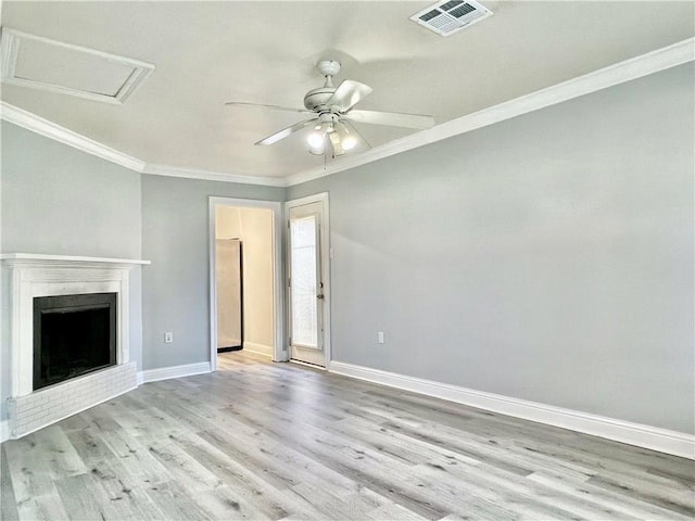 unfurnished living room with visible vents, baseboards, wood finished floors, and crown molding