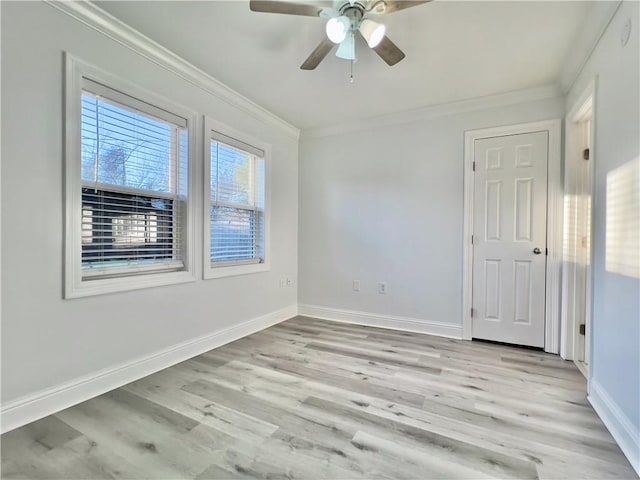 spare room with ceiling fan, light wood-type flooring, baseboards, and ornamental molding