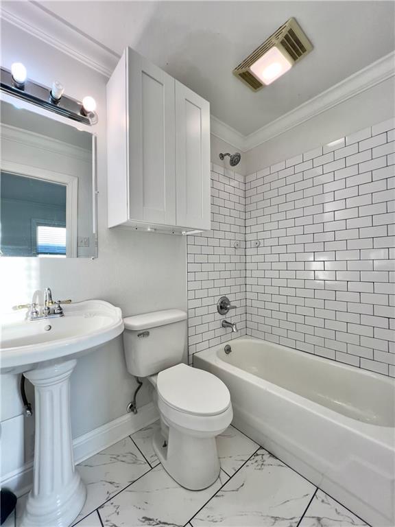 bathroom with visible vents, tub / shower combination, crown molding, toilet, and marble finish floor