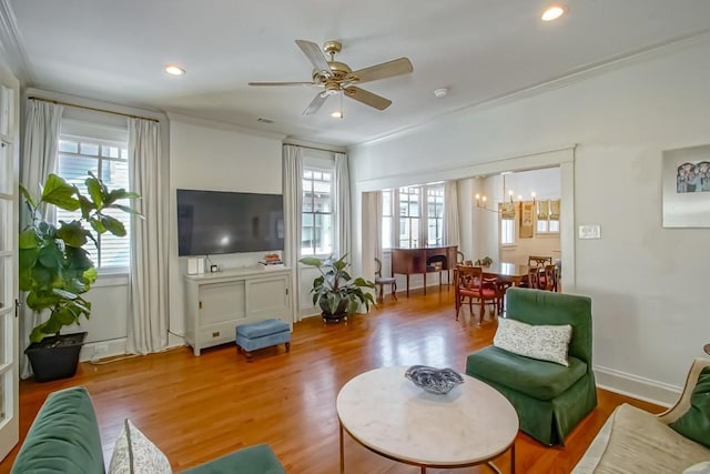 living area with wood finished floors, visible vents, recessed lighting, crown molding, and ceiling fan with notable chandelier