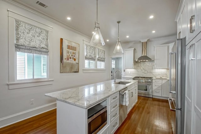 kitchen with visible vents, dark wood finished floors, appliances with stainless steel finishes, wall chimney exhaust hood, and backsplash