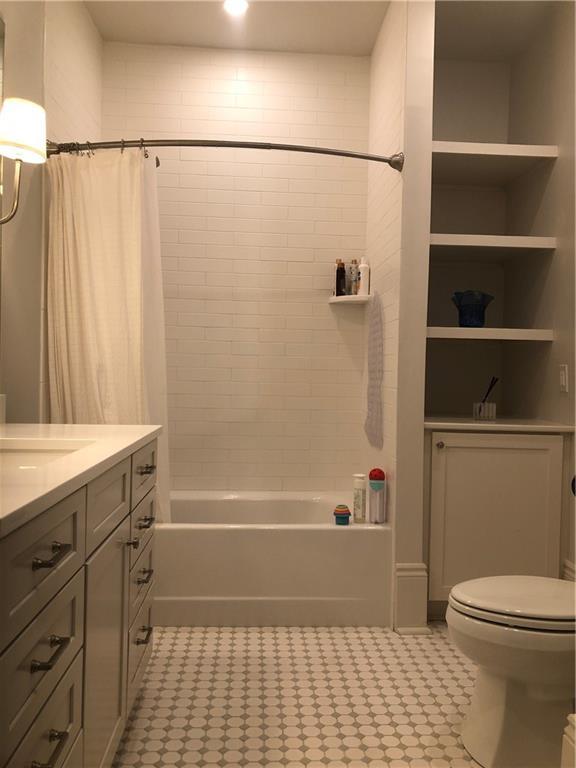 2405 Octavia St, New Orleans, LA 70115 - full bathroom with vanity, toilet, and shower / bathtub combination with curtain