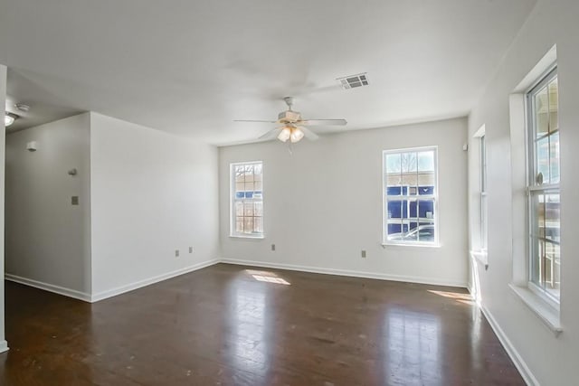 unfurnished room featuring visible vents, a healthy amount of sunlight, baseboards, and ceiling fan