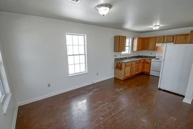 kitchen featuring dark wood-style floors, white appliances, baseboards, and a sink