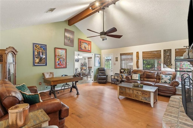 living room featuring light wood finished floors, beamed ceiling, a textured ceiling, and ceiling fan