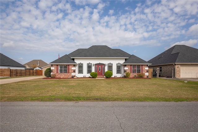 view of front of property featuring stucco siding, a front yard, driveway, and fence