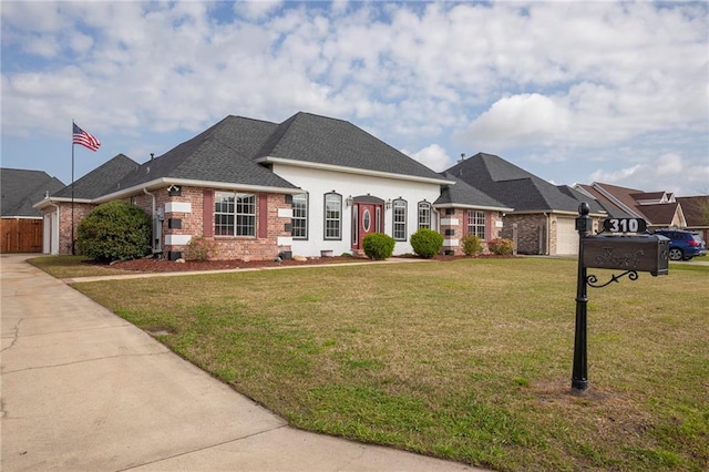 view of front facade featuring driveway, roof with shingles, a front yard, a garage, and brick siding