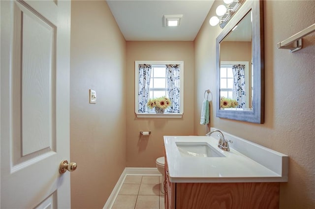 half bathroom with tile patterned flooring, toilet, vanity, and baseboards