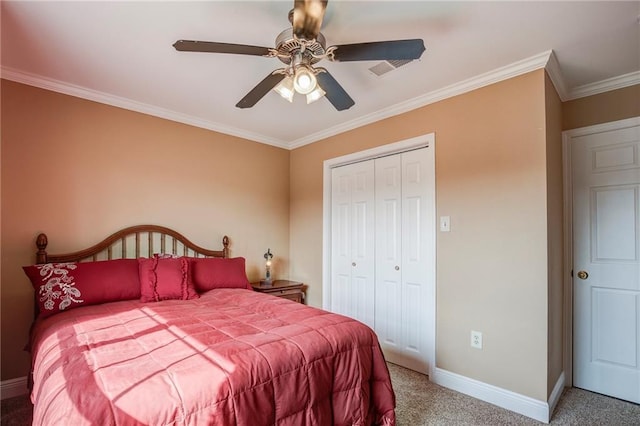 carpeted bedroom with ceiling fan, a closet, baseboards, and ornamental molding