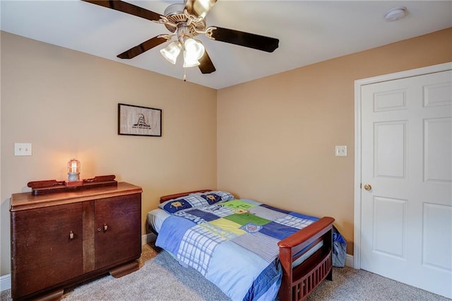 carpeted bedroom with a ceiling fan and baseboards