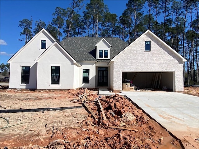 view of front of property with stucco siding, a garage, driveway, and roof with shingles