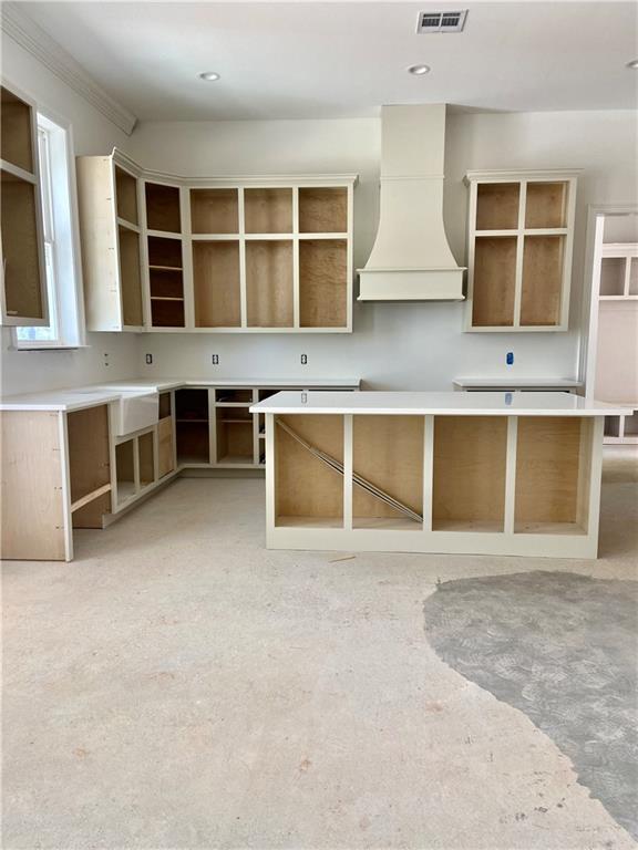 kitchen with visible vents, a kitchen island, premium range hood, recessed lighting, and open shelves