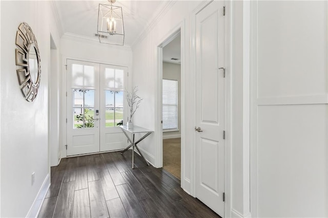 entrance foyer featuring a notable chandelier, baseboards, crown molding, and dark wood-type flooring