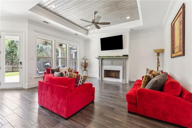 living area with crown molding, a raised ceiling, and ceiling fan