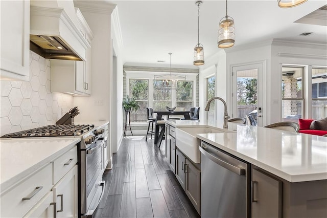 kitchen with plenty of natural light, appliances with stainless steel finishes, light countertops, and custom range hood