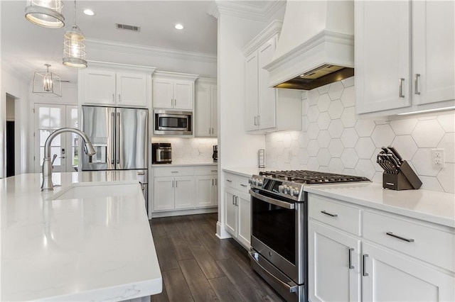 kitchen with visible vents, premium range hood, ornamental molding, appliances with stainless steel finishes, and a sink