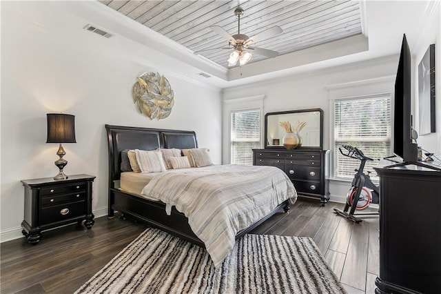 bedroom with visible vents, a tray ceiling, dark wood-style floors, wooden ceiling, and crown molding