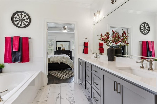 bathroom with double vanity, ensuite bath, a garden tub, and a sink