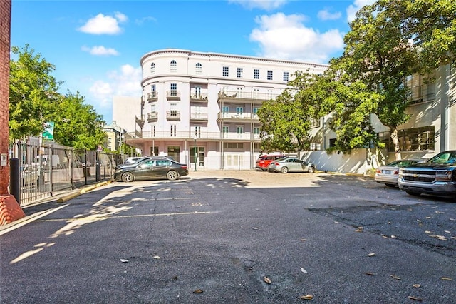 view of property with uncovered parking and fence