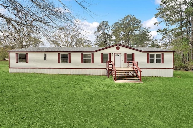 manufactured / mobile home featuring a front yard and roof with shingles