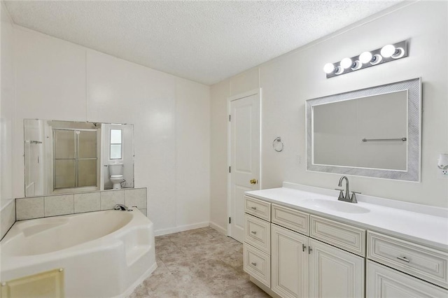 full bath with vanity, a shower stall, a textured ceiling, a garden tub, and toilet