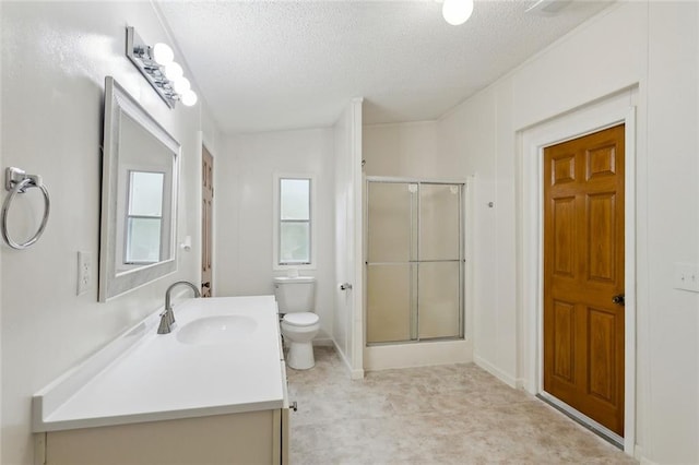 bathroom featuring a stall shower, toilet, vanity, and a textured ceiling