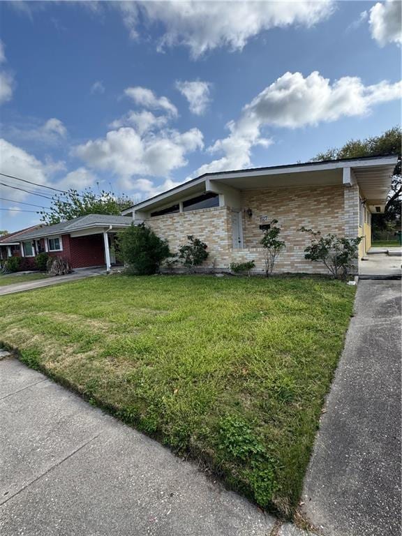 1127 Nursery Ave, Metairie, LA 70005 - view of front of home with driveway, brick siding, an attached garage, and a front lawn