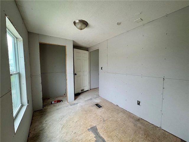 unfurnished bedroom with a closet and a textured ceiling