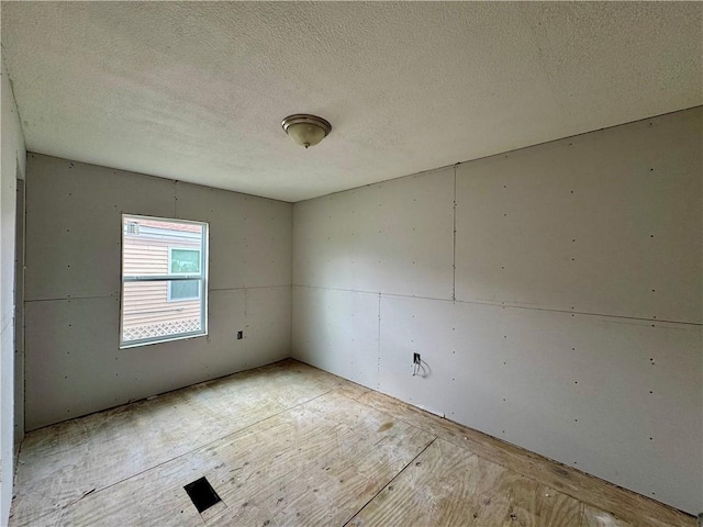 unfurnished room featuring a textured ceiling