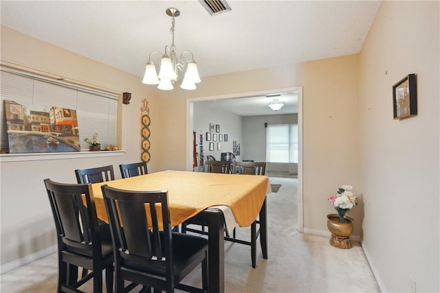 dining area with baseboards, visible vents, and a chandelier