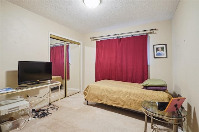 carpeted bedroom with a closet and a textured ceiling