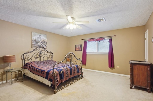 carpeted bedroom with a ceiling fan, baseboards, visible vents, and a textured ceiling