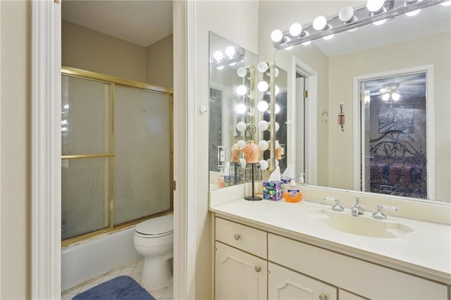 bathroom with vanity, a ceiling fan, enclosed tub / shower combo, tile patterned flooring, and toilet