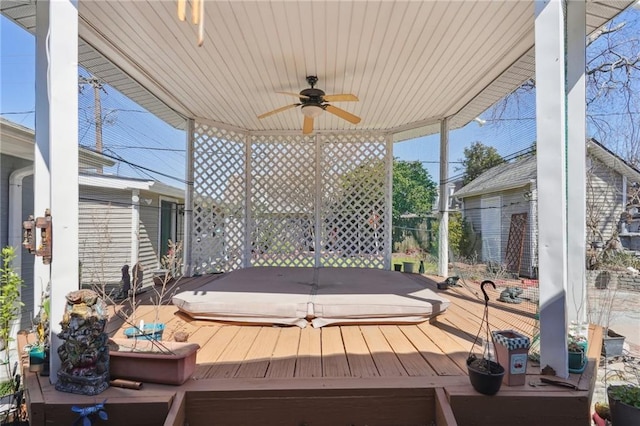 wooden terrace featuring a covered hot tub and ceiling fan