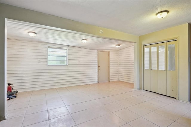 empty room featuring light tile patterned floors and a textured ceiling