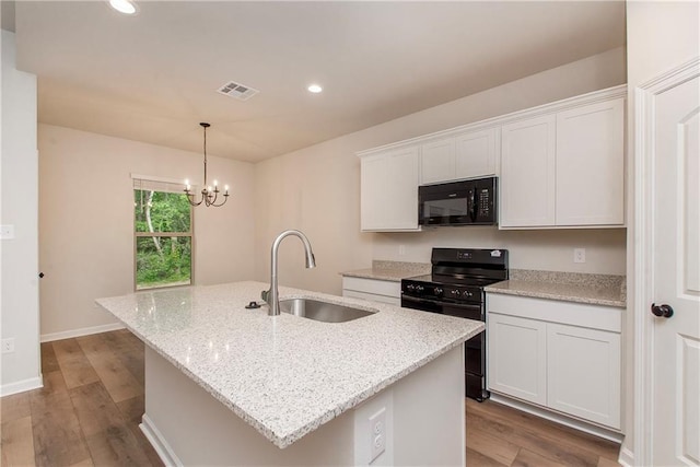 20069 Narretto Rd, Loranger, LA 70446 - kitchen with a sink, wood finished floors, visible vents, a center island with sink, and black appliances