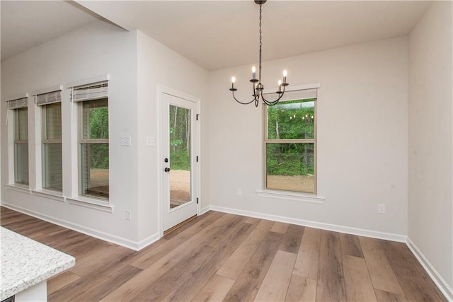20069 Narretto Rd, Loranger, LA 70446 - unfurnished dining area featuring baseboards, an inviting chandelier, and wood finished floors