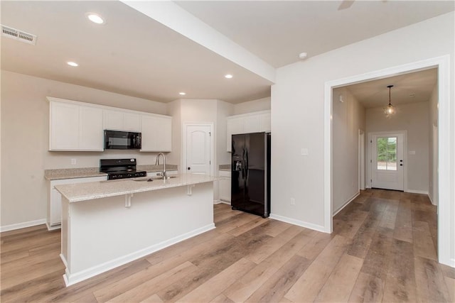 20069 Narretto Rd, Loranger, LA 70446 - kitchen featuring visible vents, a sink, white cabinets, black appliances, and light wood-style floors