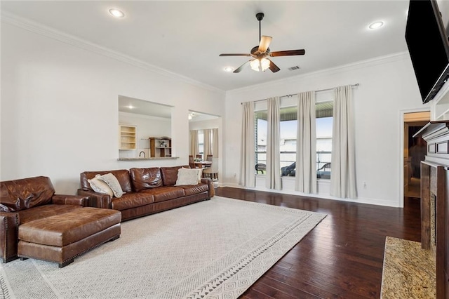 living area with wood finished floors, baseboards, recessed lighting, ceiling fan, and crown molding