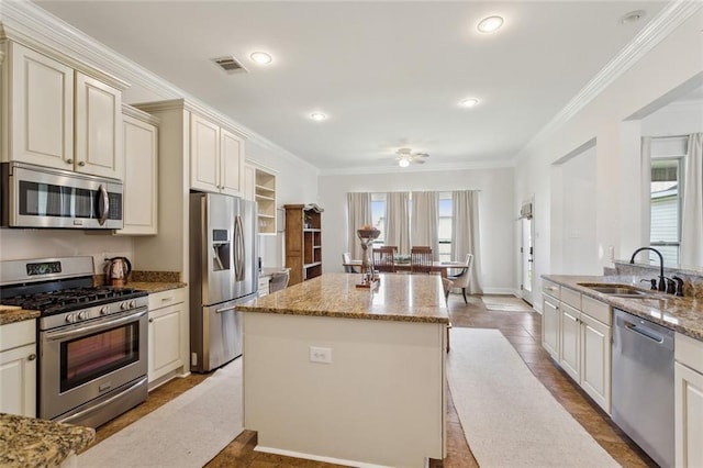 kitchen with a sink, crown molding, visible vents, and stainless steel appliances