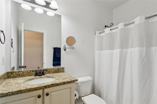 bathroom with vanity, curtained shower, and toilet