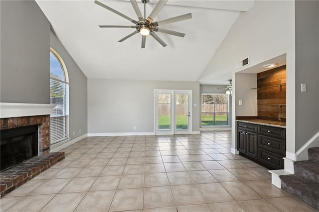 unfurnished living room with light tile patterned floors, visible vents, a healthy amount of sunlight, and a ceiling fan