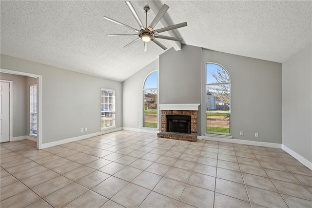 unfurnished living room featuring a wealth of natural light, a brick fireplace, vaulted ceiling with beams, and a ceiling fan